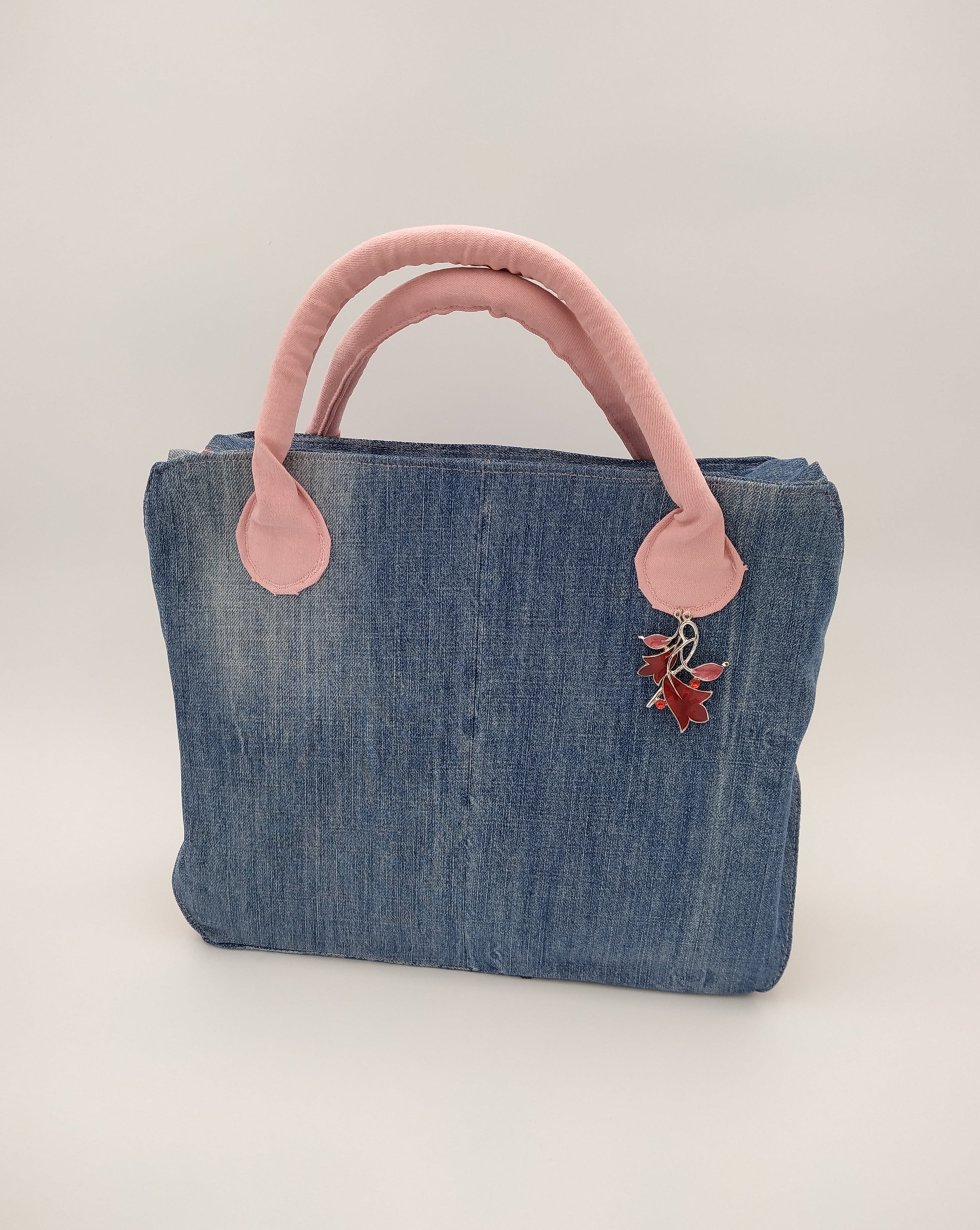 sac bicolore jean et rose: vue de face : corps du sac en jean bleu recyclé et anses en jean rose décorées d'un bijou rose et argent