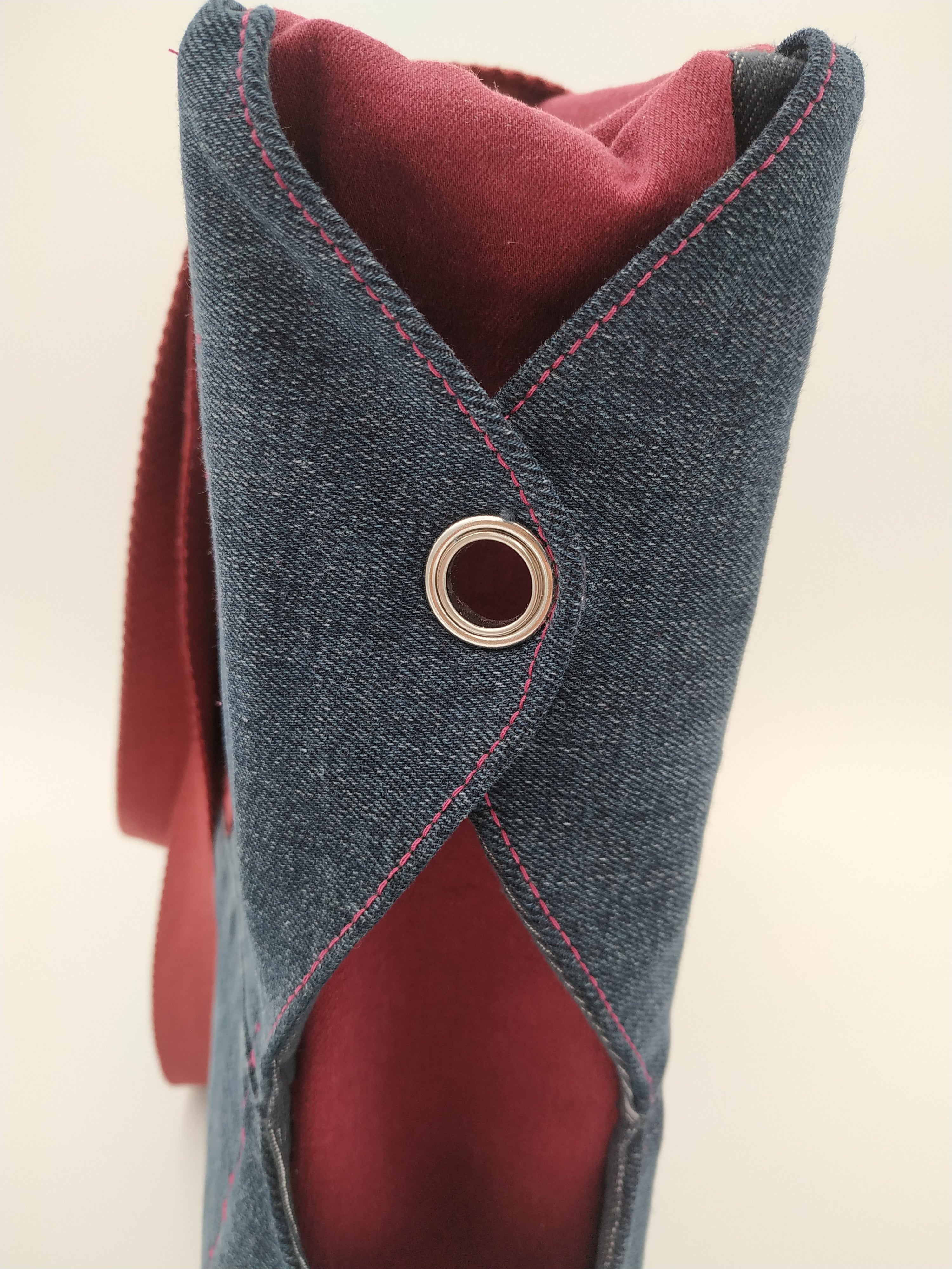 Sac bicolore grand modèle - détail côté : 2 ailettes en jean sombre attachées par un oeillet sur fond de jean rouge